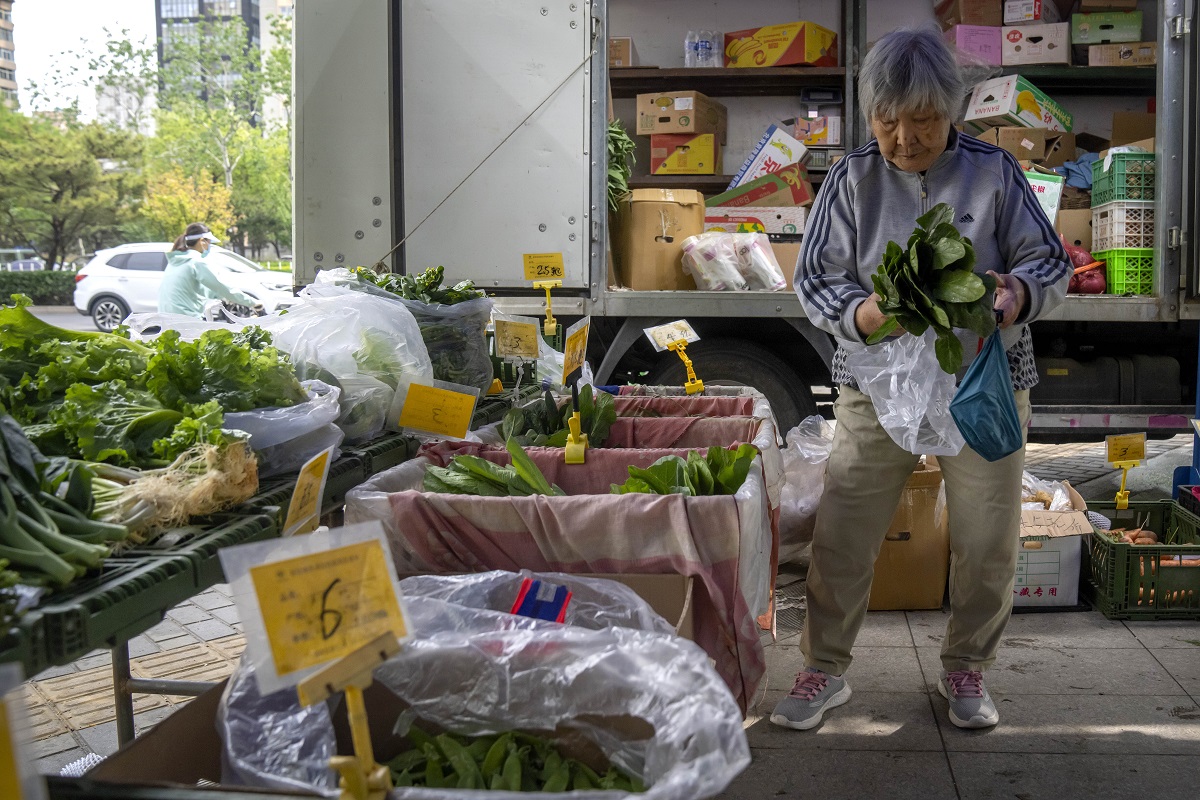 china a woman shops for fresh vegetables at a pop up market in beijing