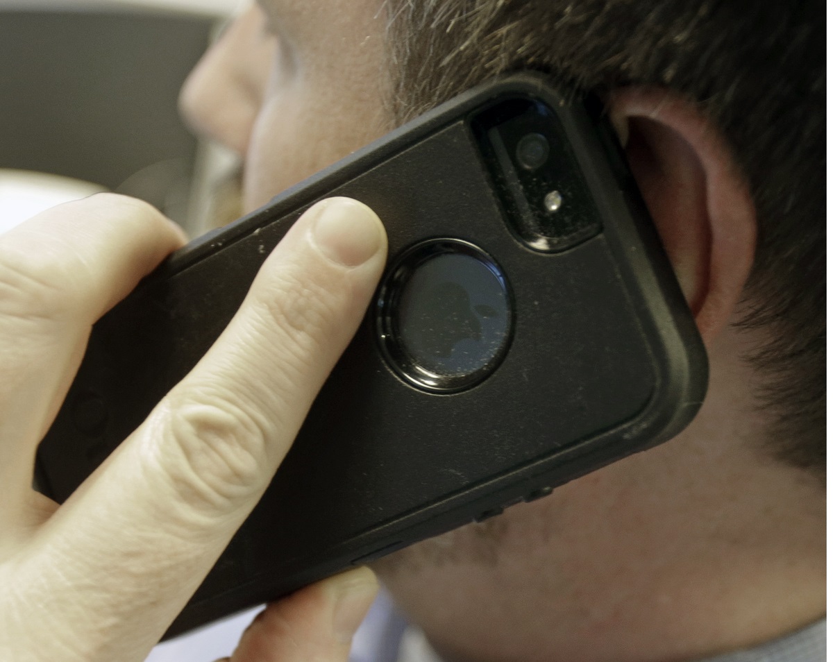 telphony a man poses holding his cell phone